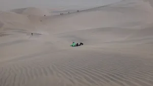 Sandboarding im Liegen in der Namib Wüste bei Swakopmund auf einfacher Holzplatte