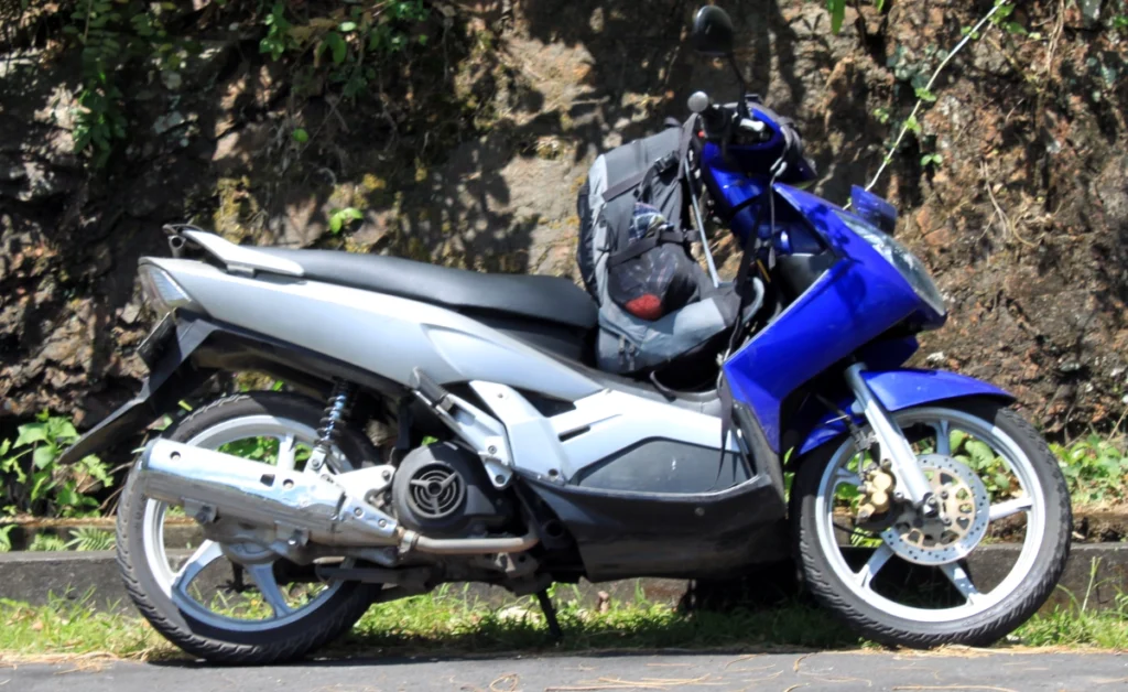 Roller mit Rucksack über den Lenker geschnallt